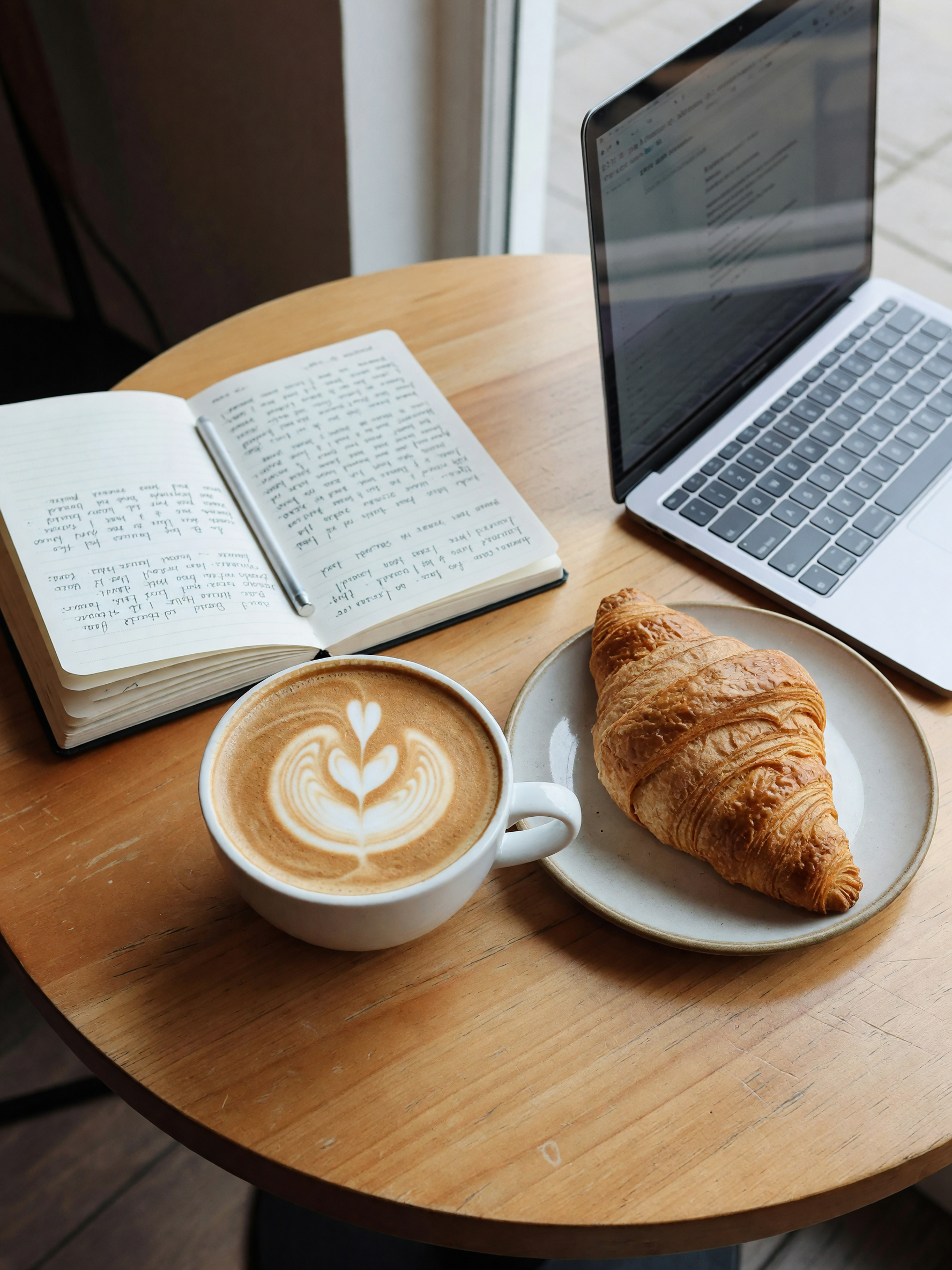laptop open, notebook out, latte that actually has art in it for once. this corn
