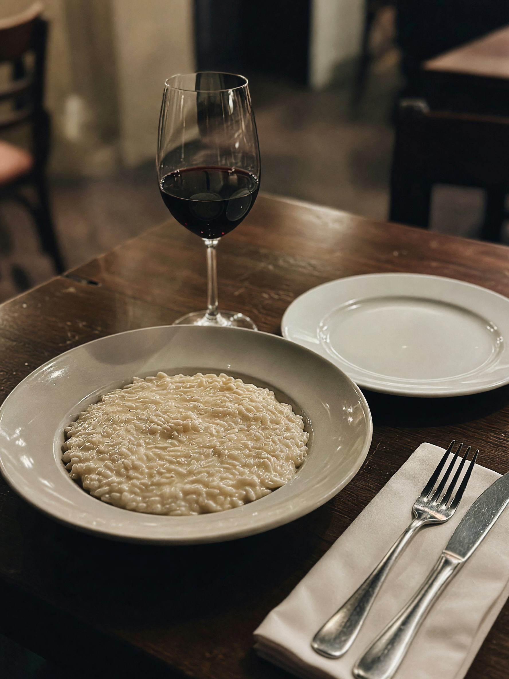 Date night done right: risotto on the plate, waiter mid-pour on the wine, and de