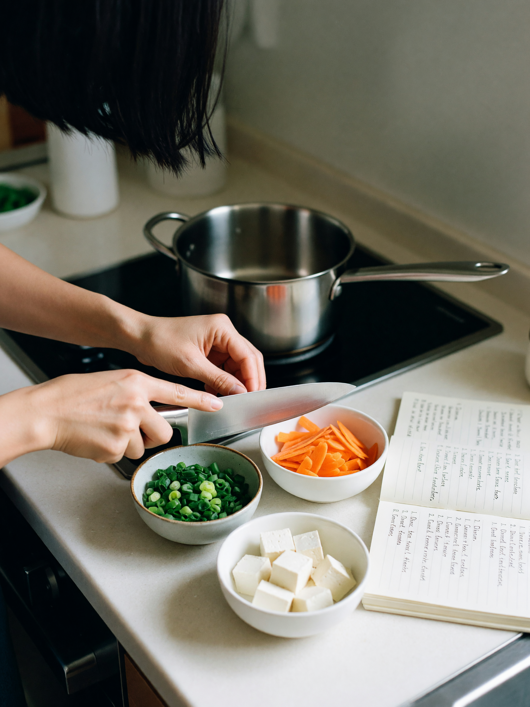 chopping vegetables while the broth simmers, trying out a new miso soup recipe f