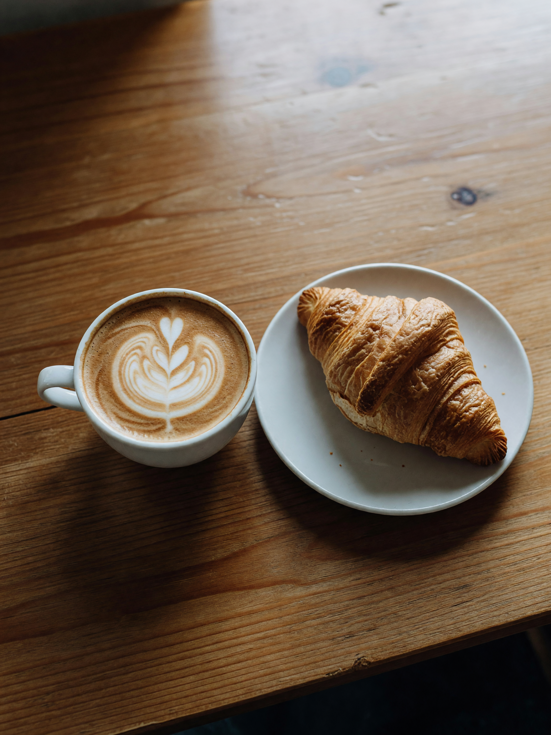oat milk latte and the last almond croissant, notebook open but not much writing