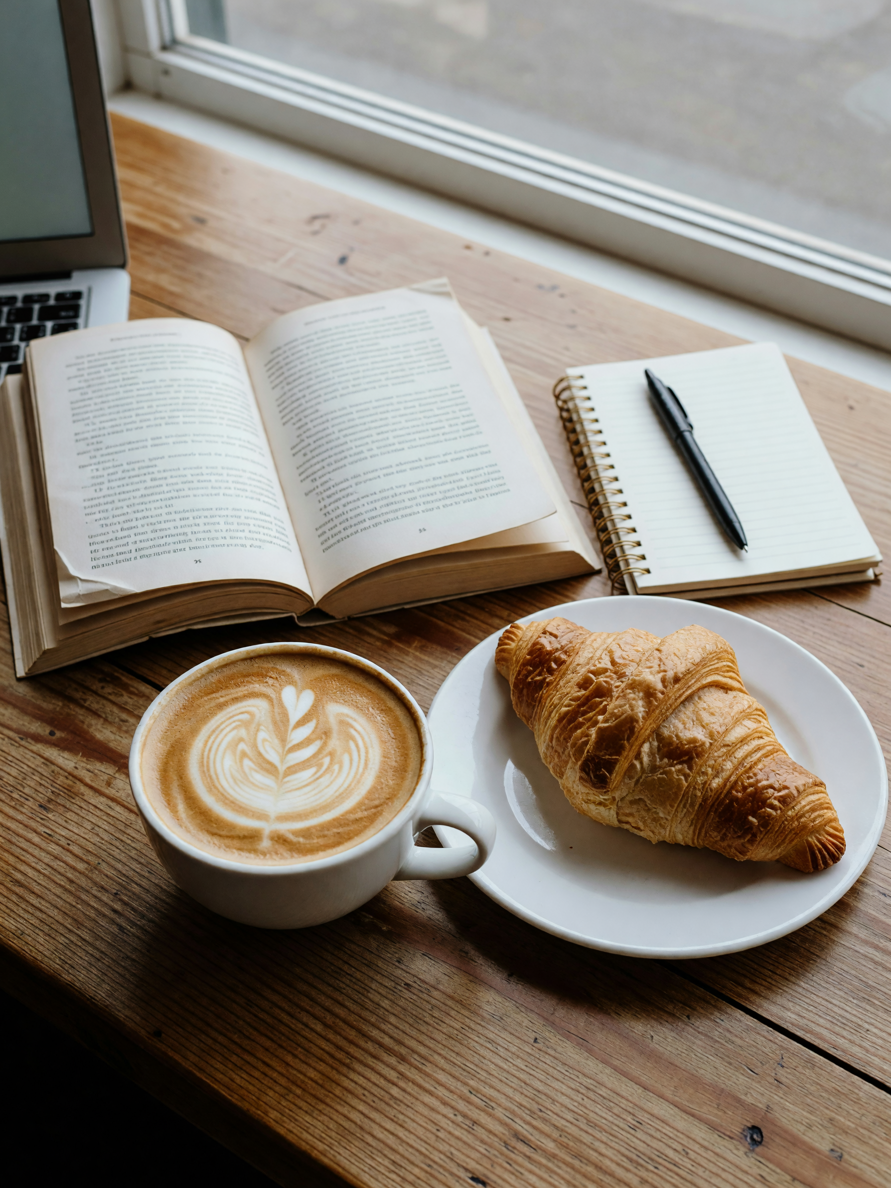 laptop open, croissant gone, still pretending I'm going to finish this chapter b